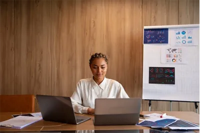 Une femme devant un bureau gérant la gestion administrative de son activité de formation
