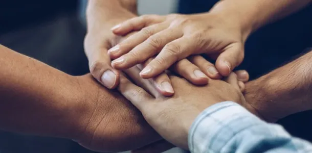 cinq mains l'une sur l'autre symbolisant l'accompagnement