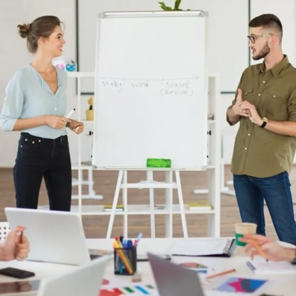 Une équipe de personnes travaillant ensemble dans un bureau, entourées d'ordinateurs et de paperasse