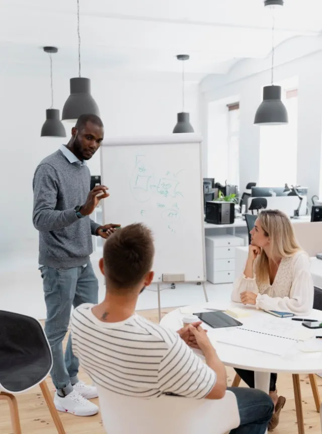 un formateur devgant 2 apprenants attentifs
